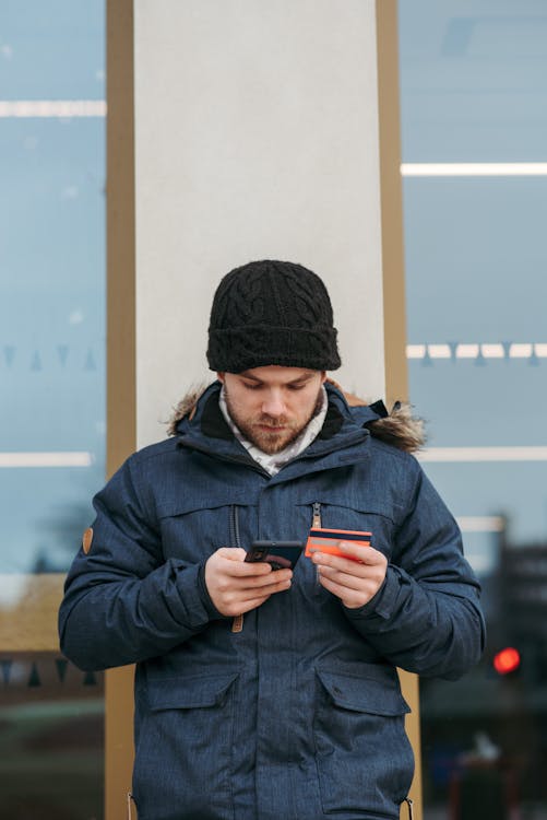 Person holding a credit card and using a smartphone for online shopping