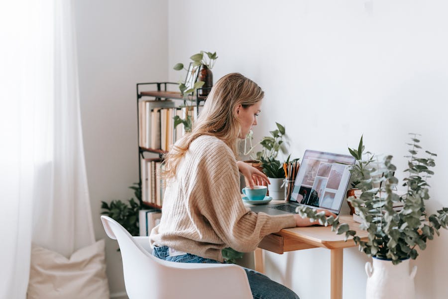 Freelancer working on a laptop with photos on the screen
